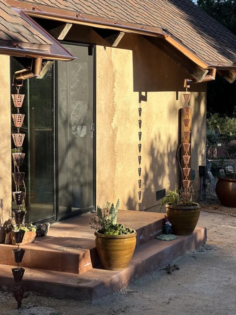 A house with a copper rain chain on the porch.