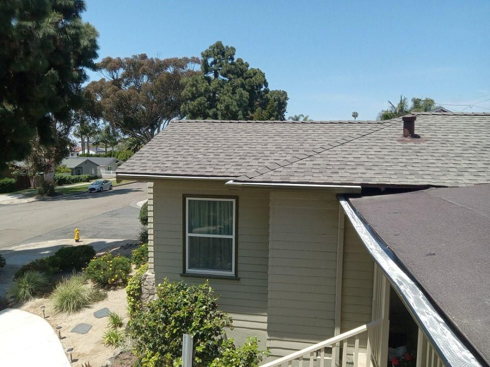 A house with a roof that has a chimney on it.