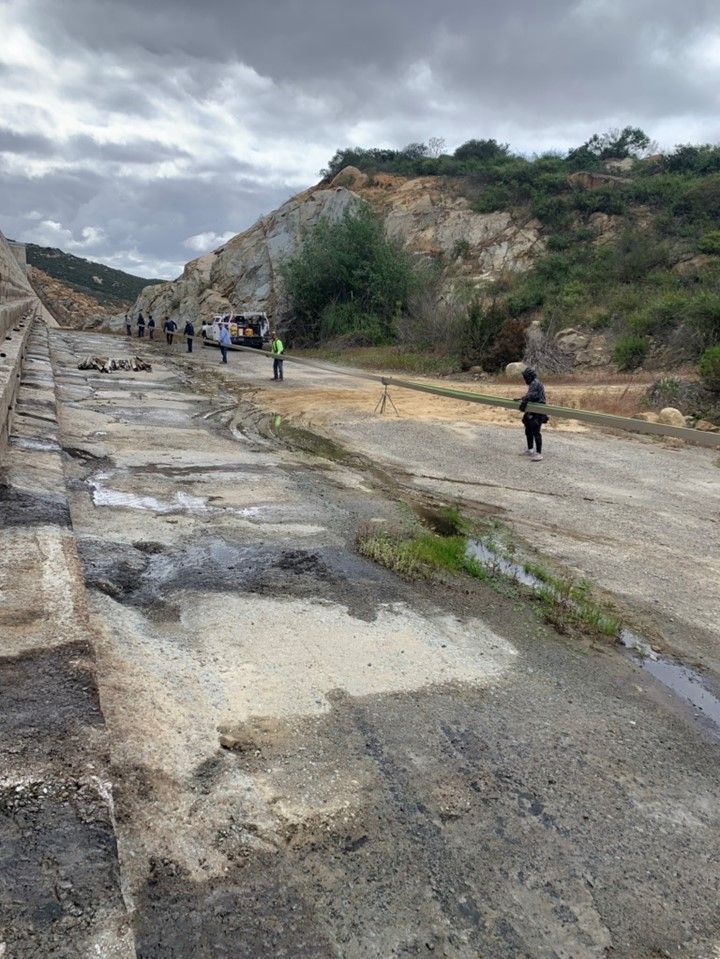 A group of people are walking down a dirt road.
