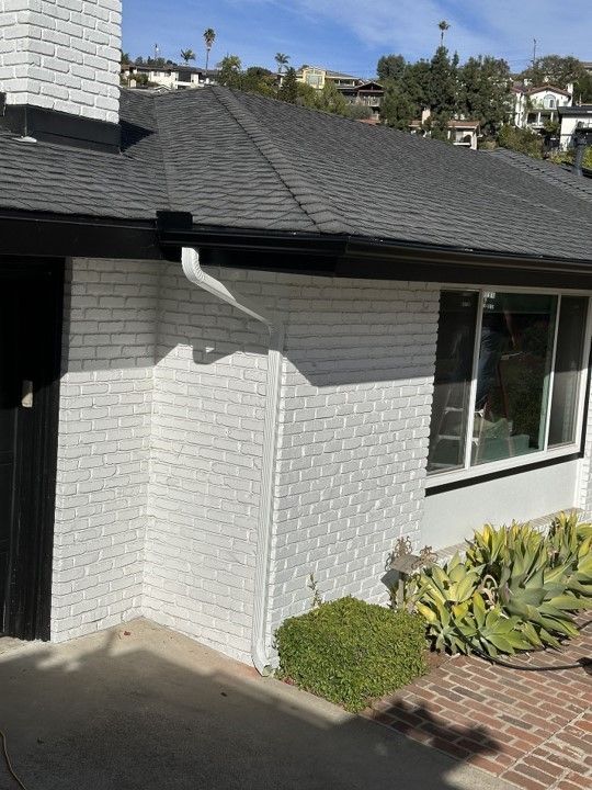 A white brick house with a black roof