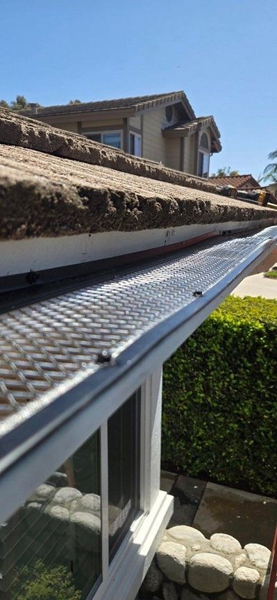 There is a gutter on the roof of a house.