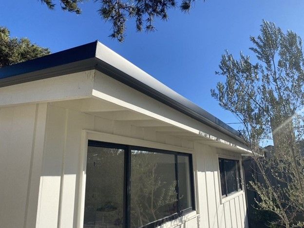 A white house with a black roof and black windows