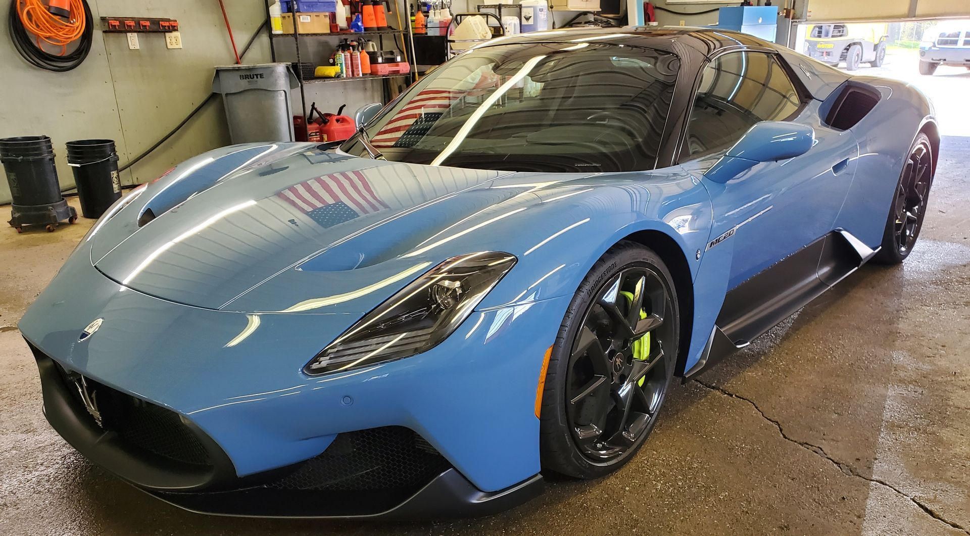 A blue sports car is parked in a garage.
