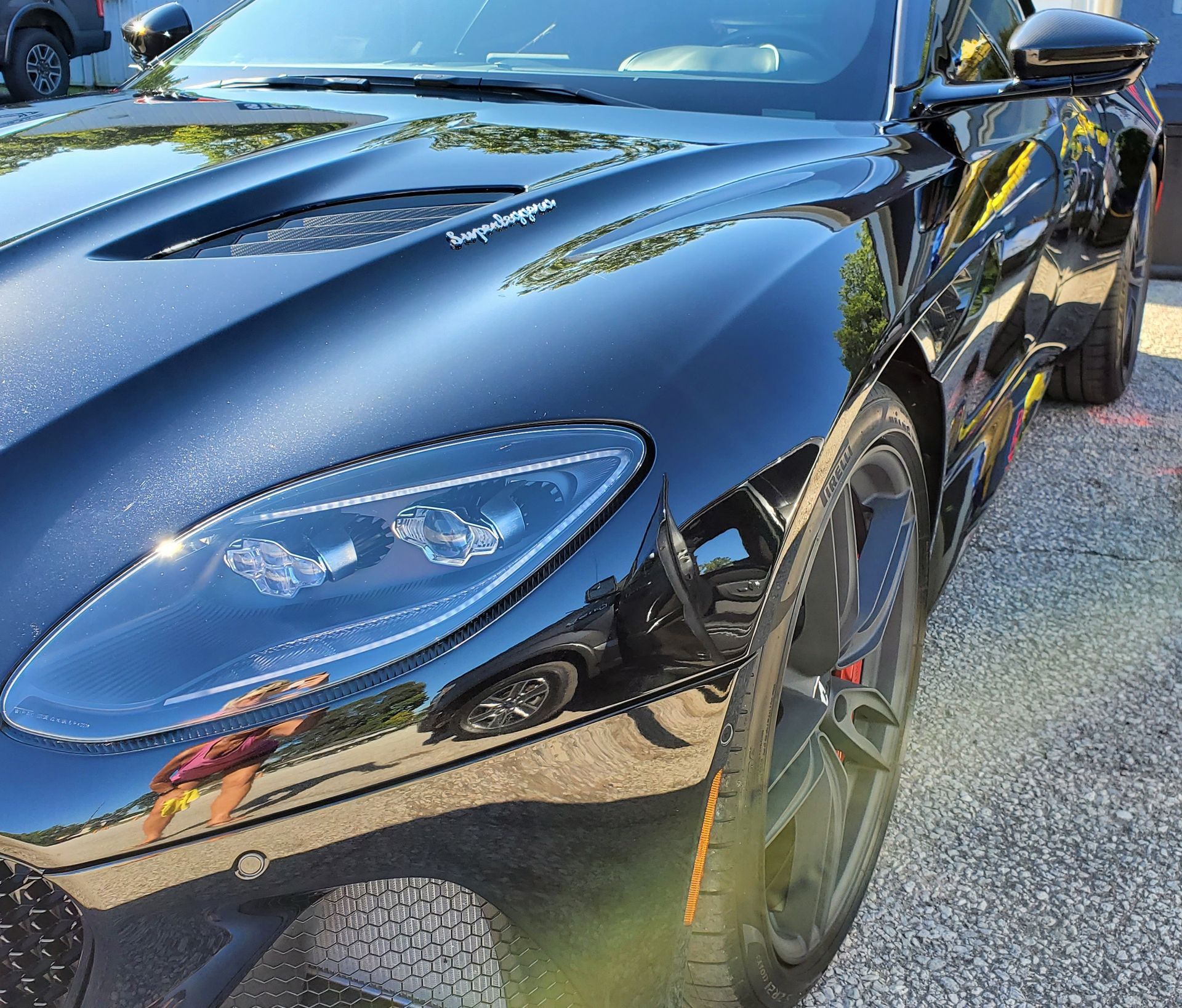 A black sports car is parked in a parking lot