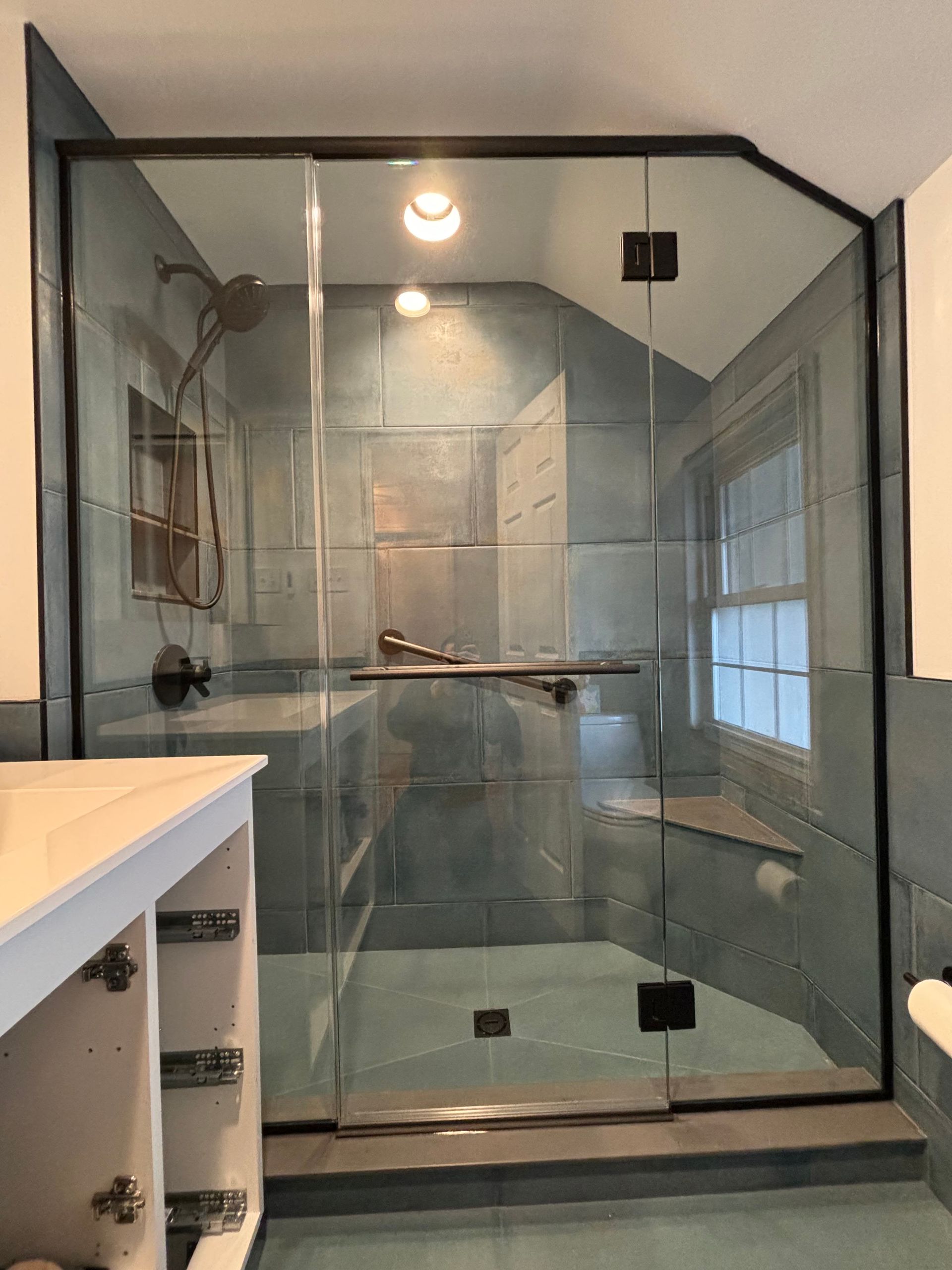 a bathroom with a glass shower door and a sink