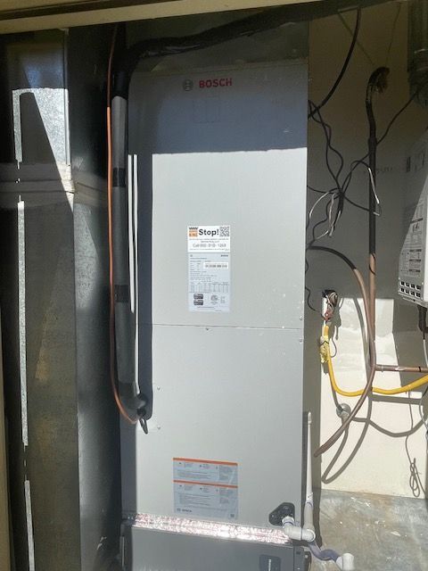 Bosch HVAC unit in a utility closet with ductwork and wiring.