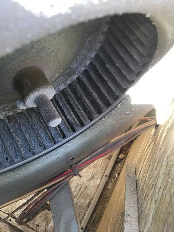 An HVAC blower fan covered in ice, likely indicating a malfunction.