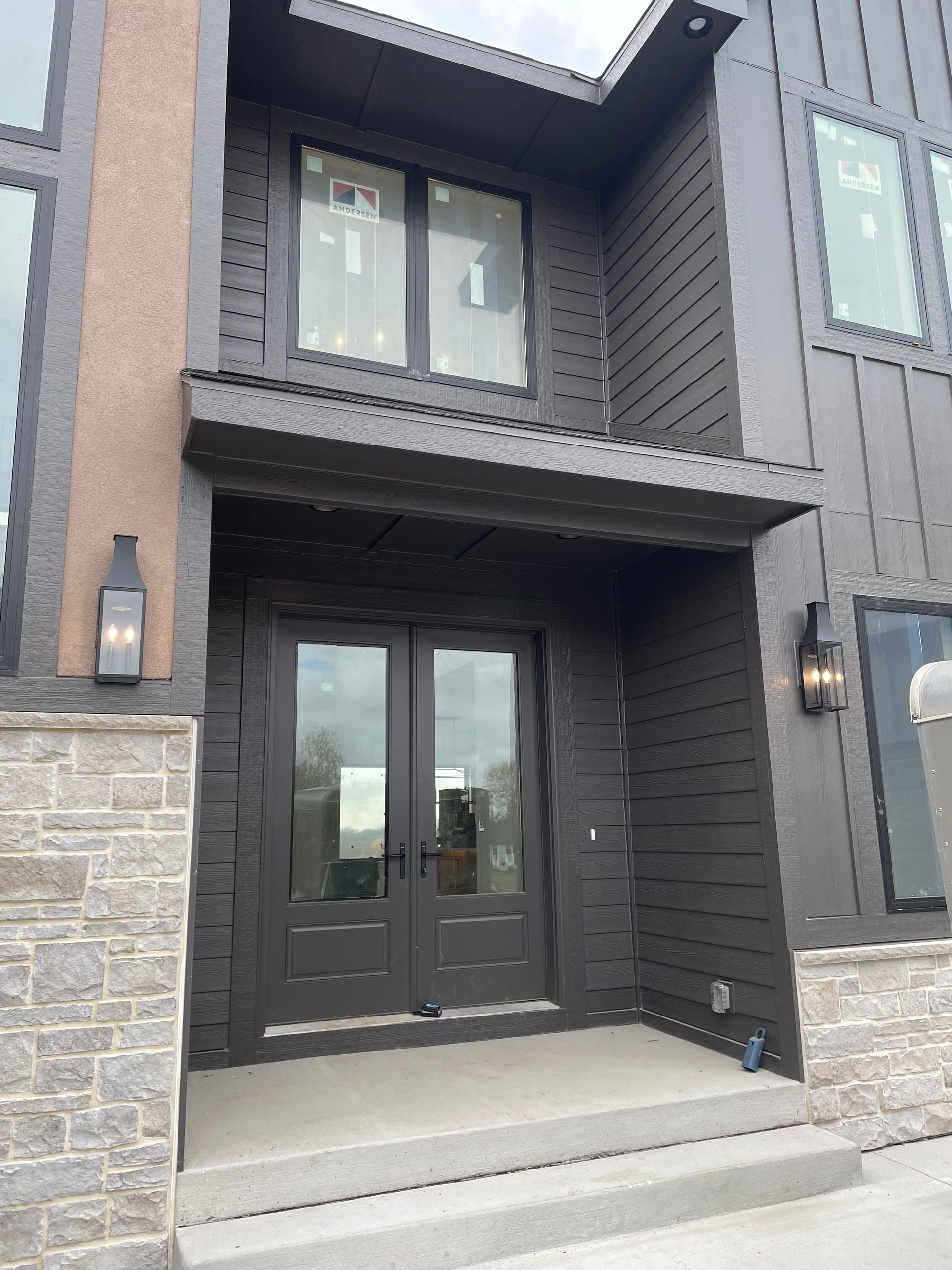 Dark brown house entrance with double doors and stone accents.