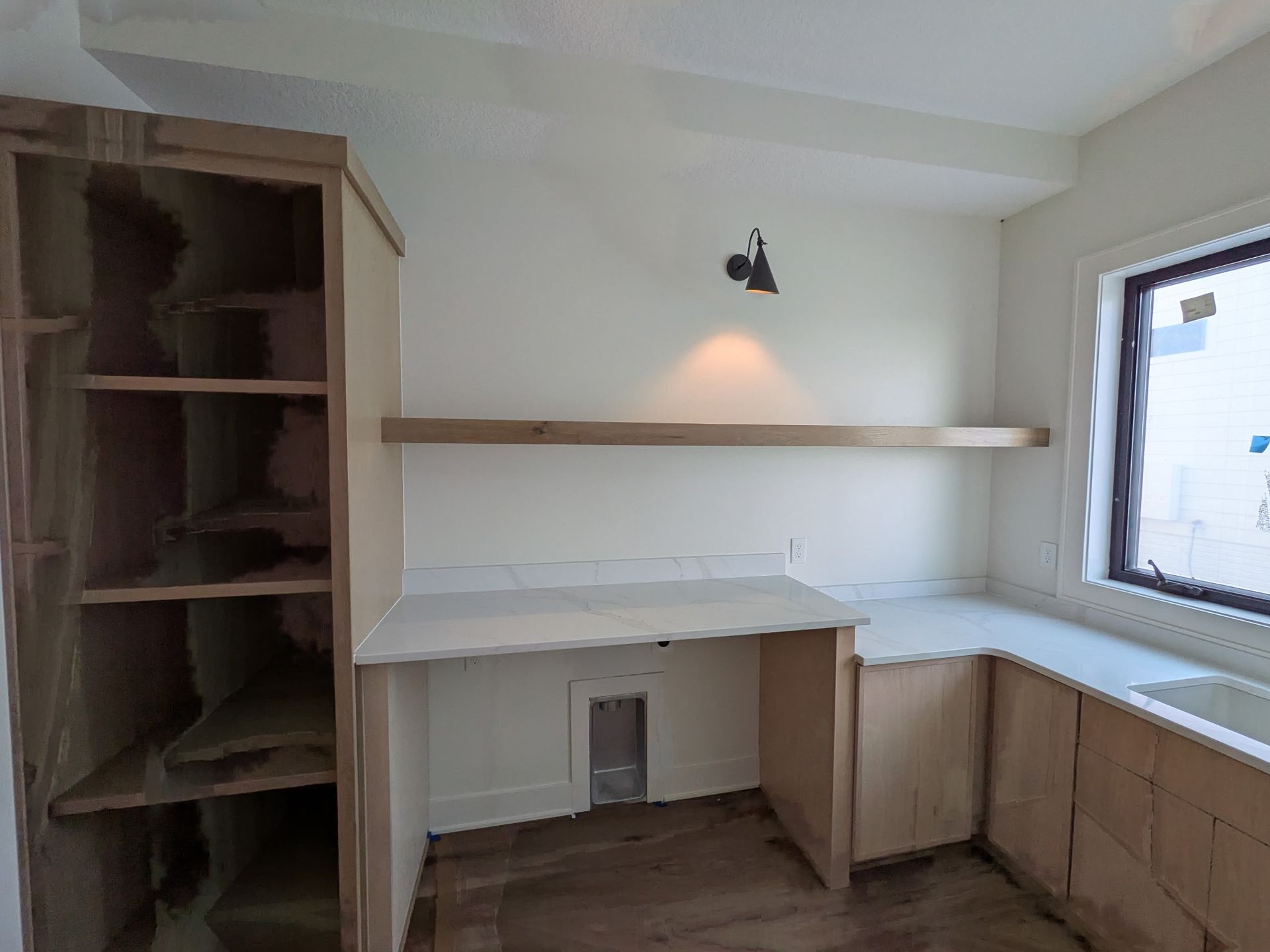 Laundry room with cabinets, counter, and shelving. Includes a window and a light.