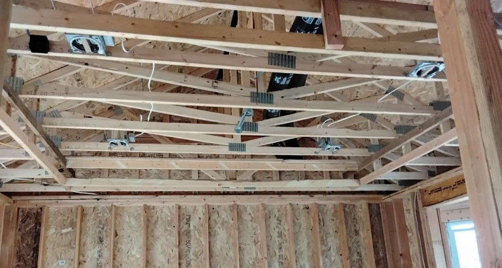 Interior view of wooden ceiling framing with electrical boxes visible.