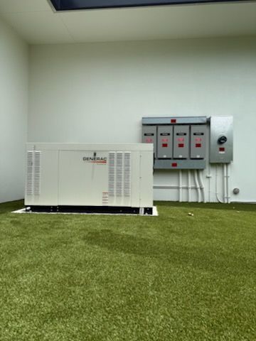 Outdoor HVAC unit and electrical panels beside a white wall on green artificial turf.