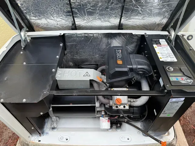 Open HVAC unit with metal panels, wiring, compressor, and black blower assembly inside a foil-lined enclosure