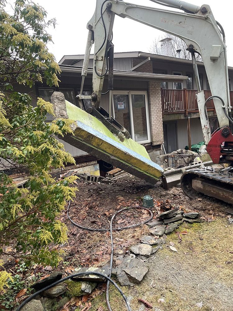 A large excavator is demolishing a house