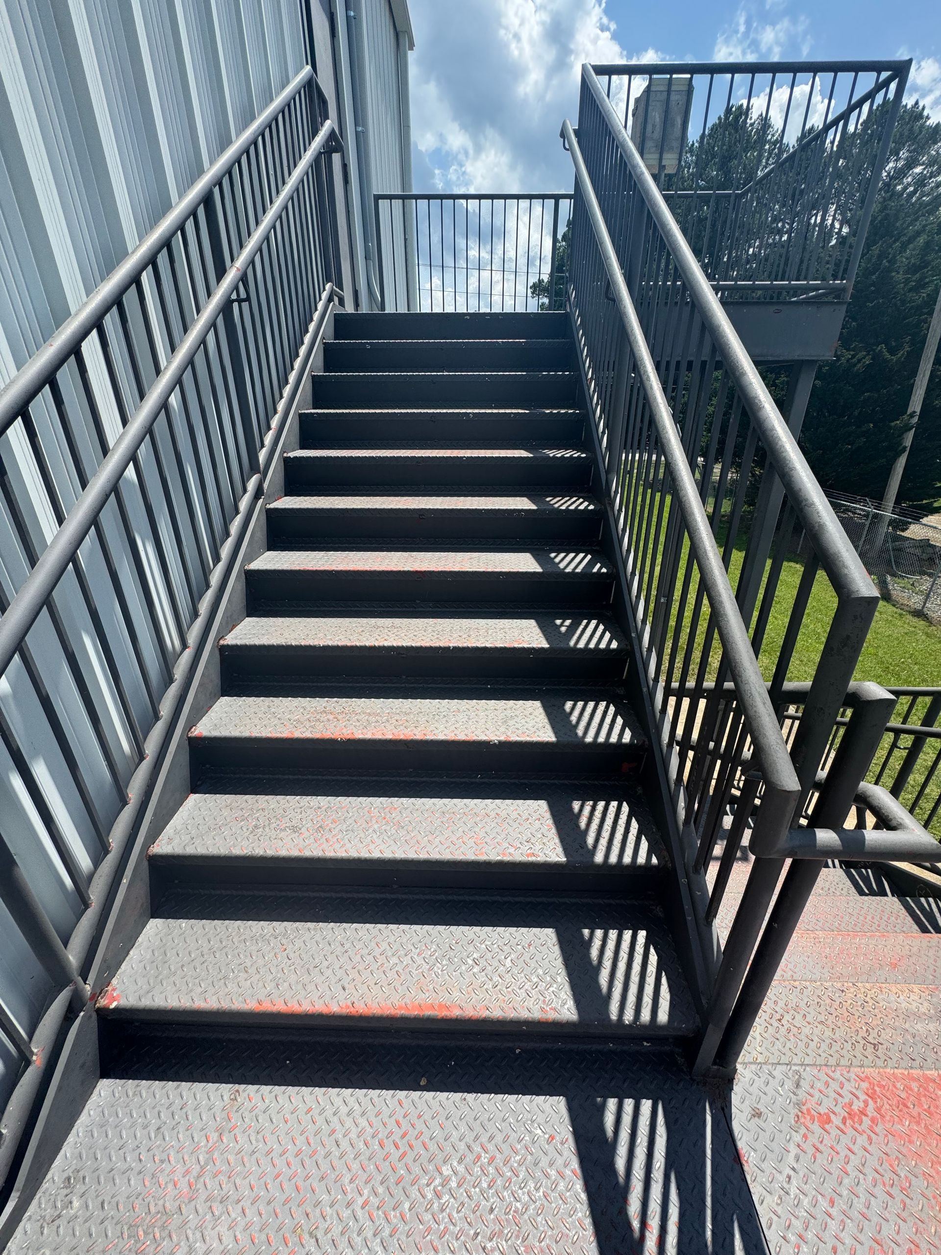 A set of stairs with a metal railing leading up to a building.