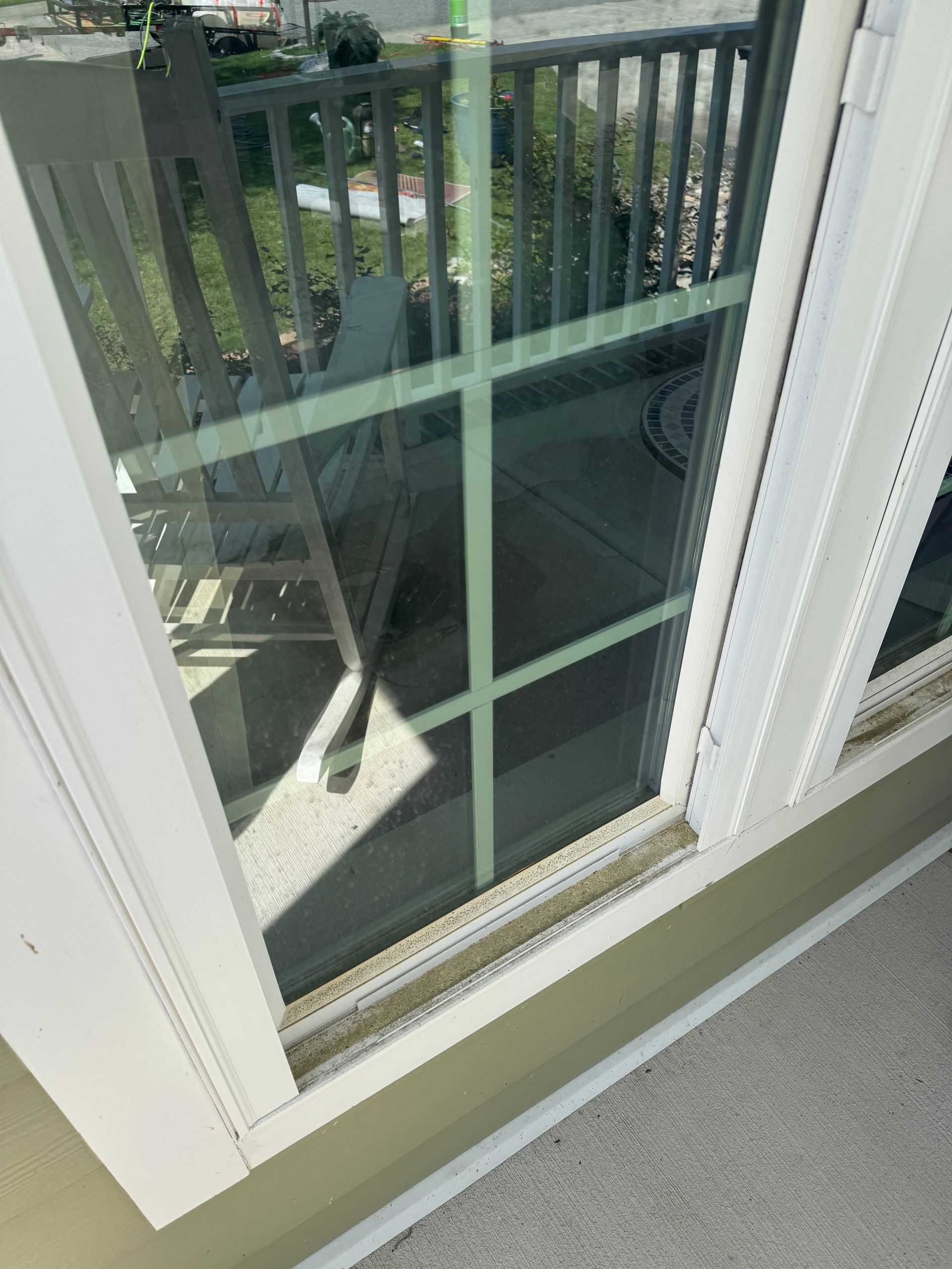 A close up of a window with a reflection of a chair in it.