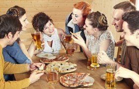 a group of people eating pizza