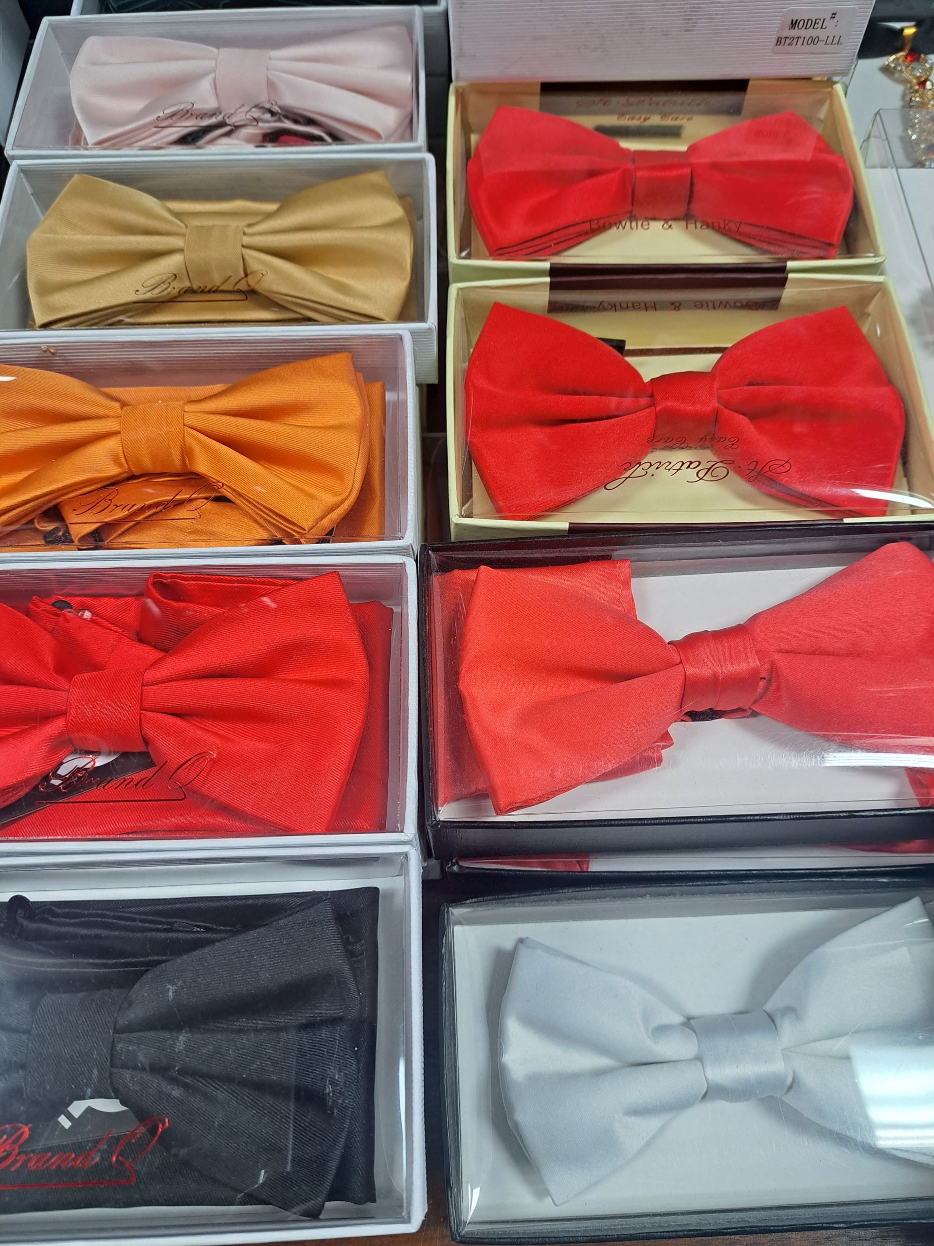 a bunch of different colored bow ties in boxes