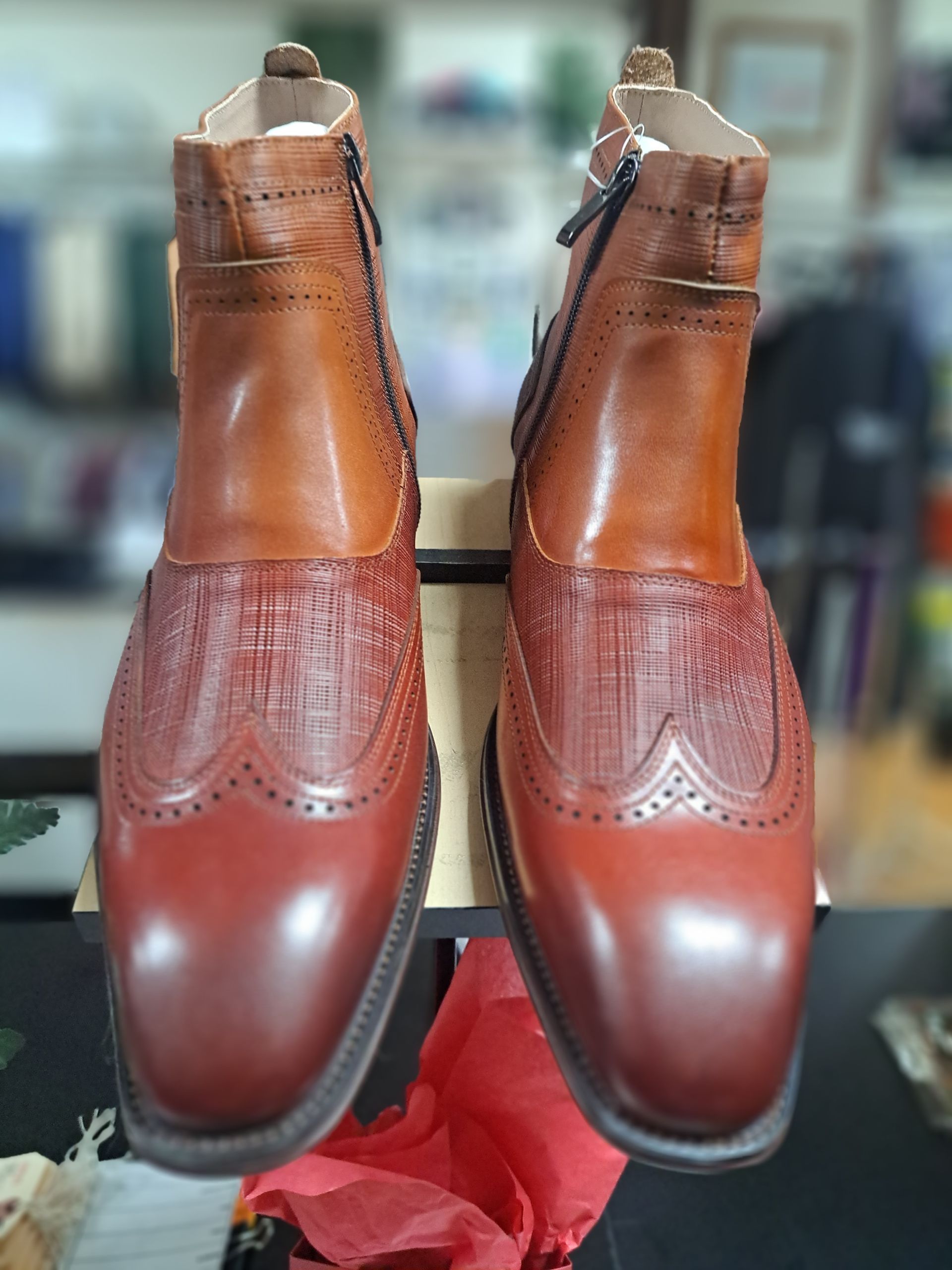 a pair of mens brown leather boots are sitting on a table .