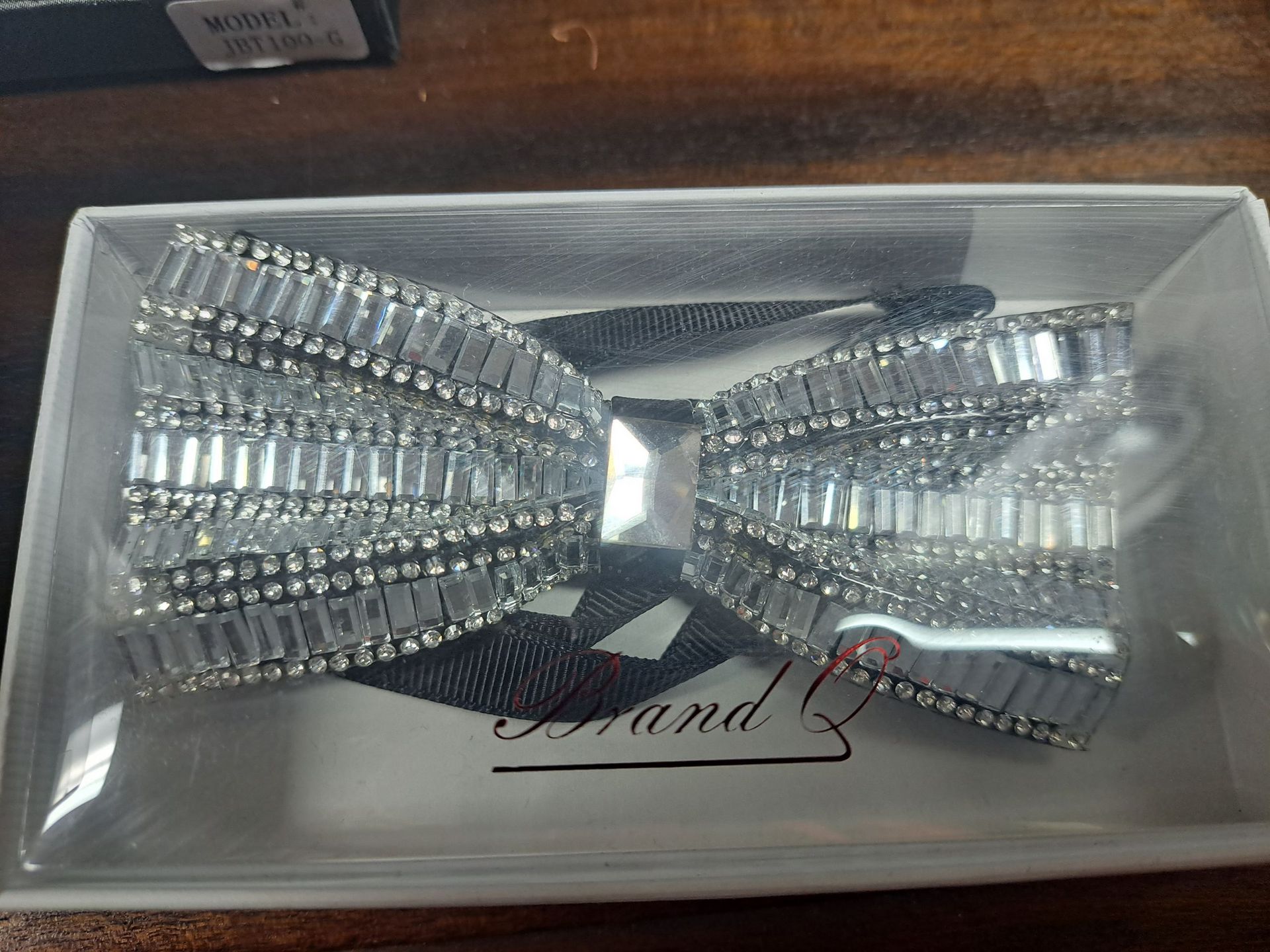 a bow tie with rhinestones is in a clear box