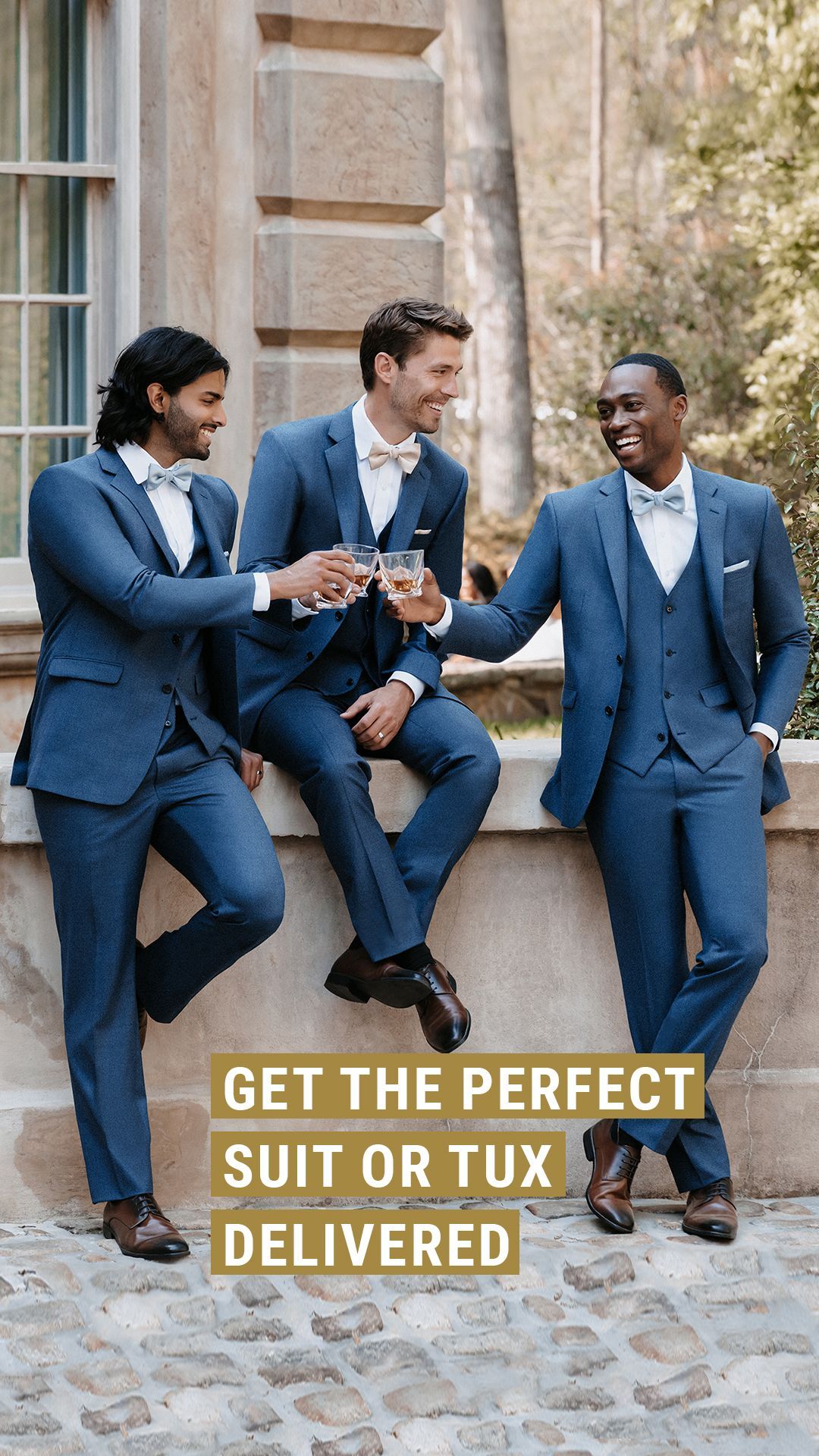 Three men in blue suits toast with champagne outdoors