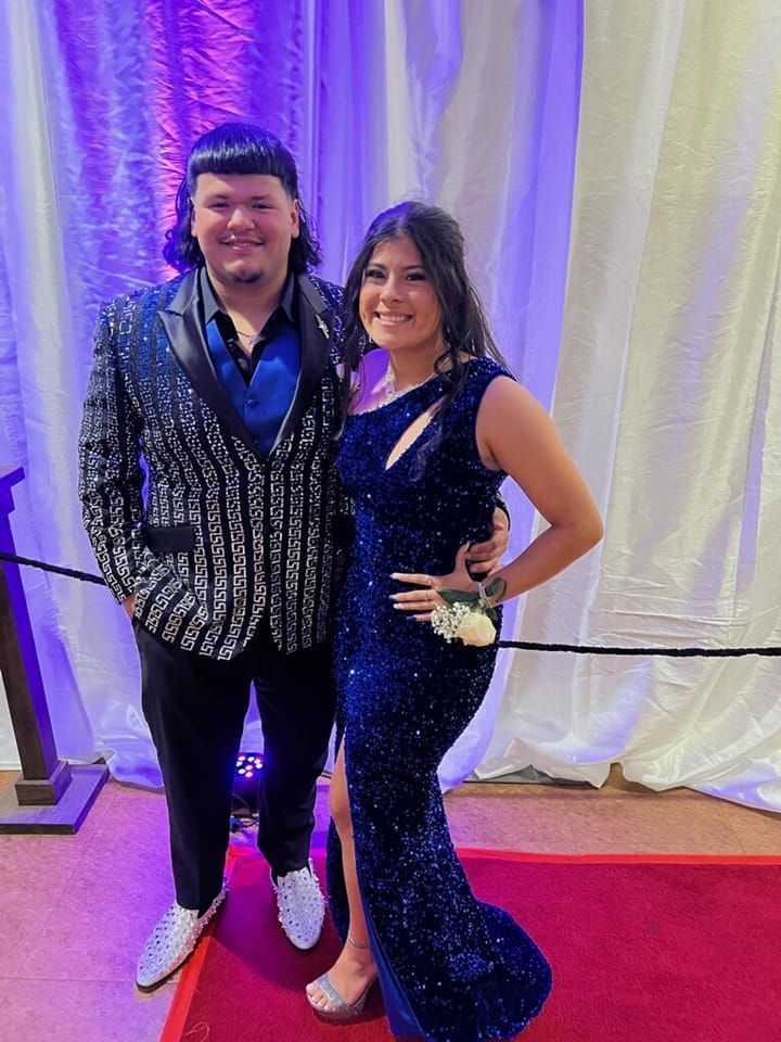 A man and a woman are posing for a picture on a red carpet.