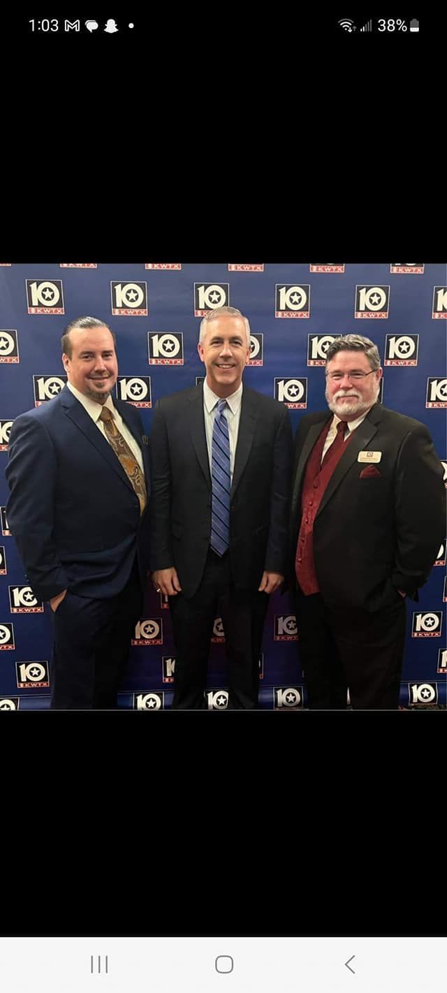 Three men in suits and ties are posing for a picture.