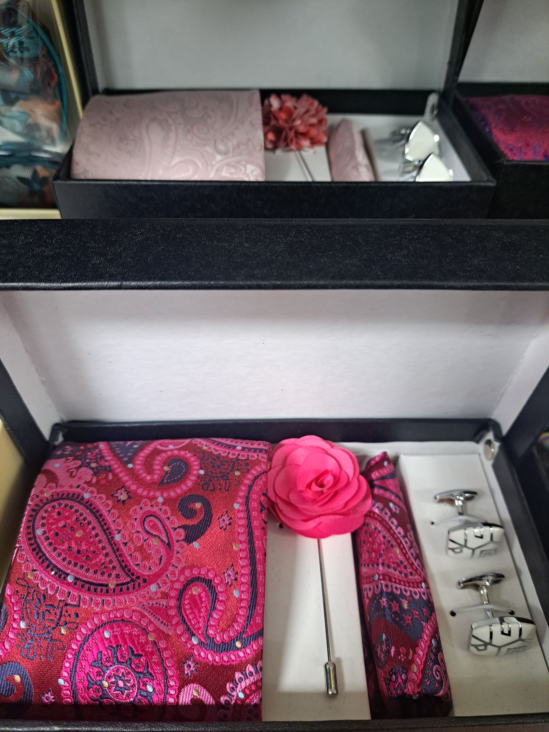 a pink tie and cufflinks set in a box
