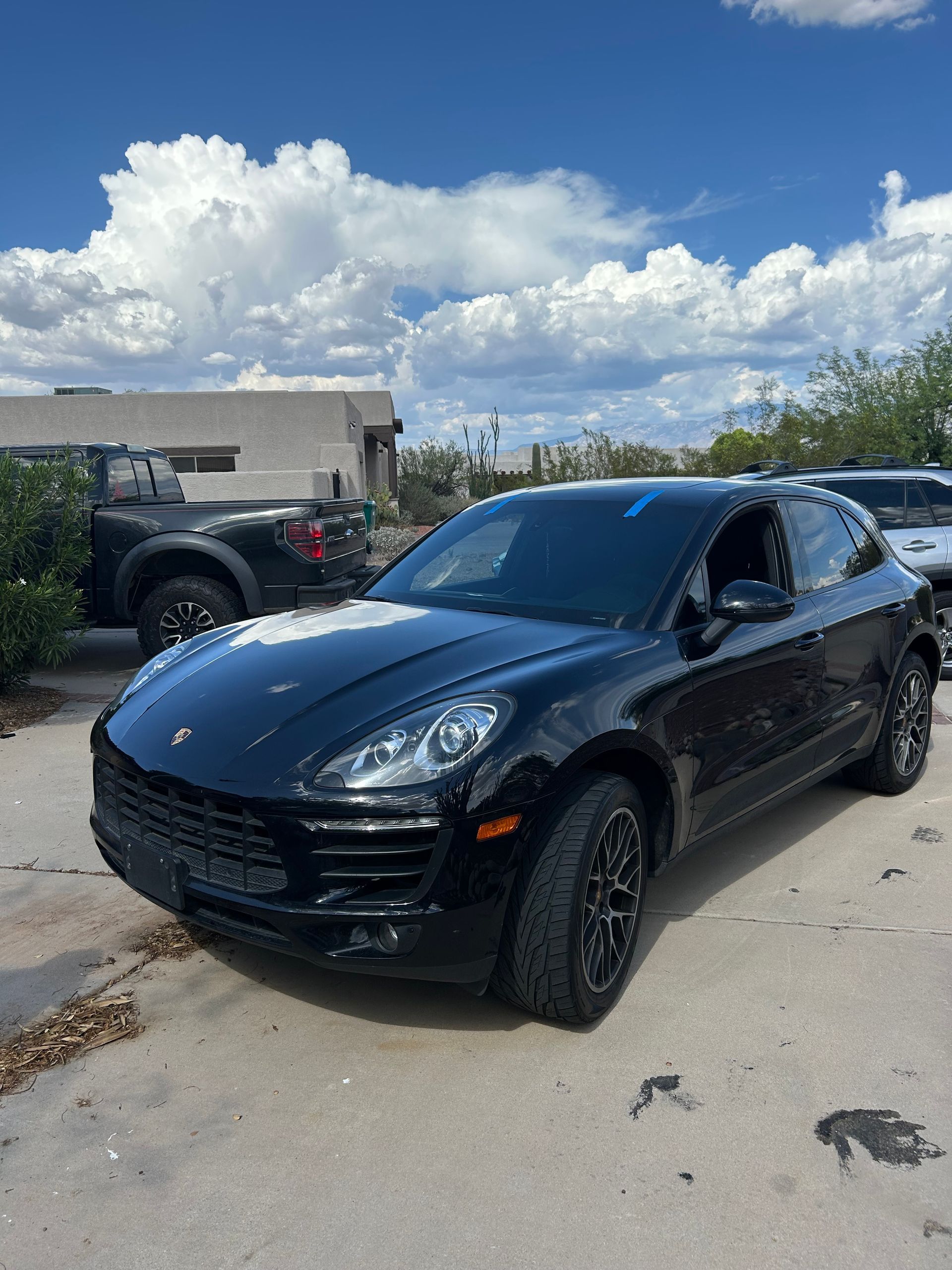 Black SUV parked on a driveway under a partly cloudy sky