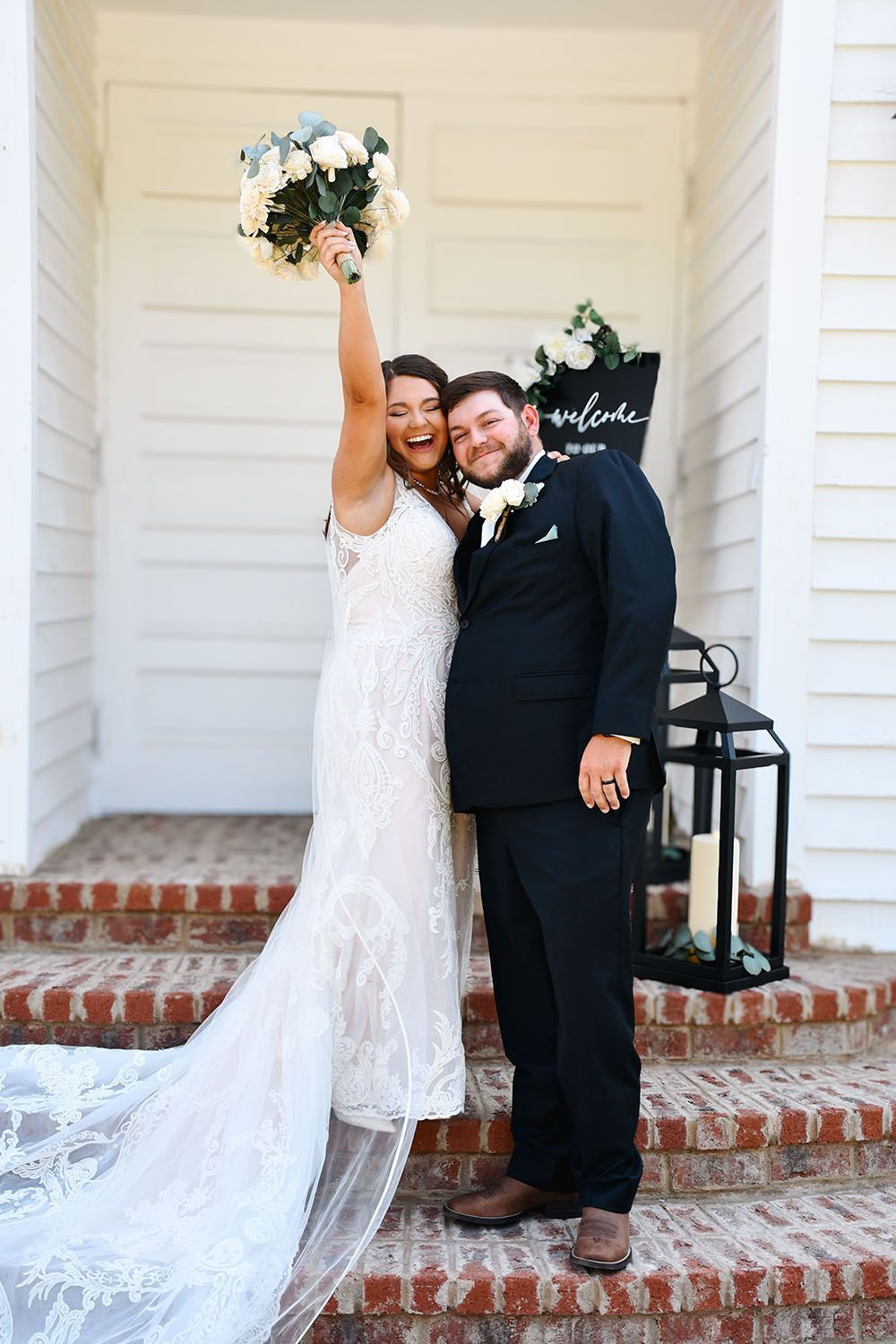 A bride and groom are posing for a picture in front of a white building.