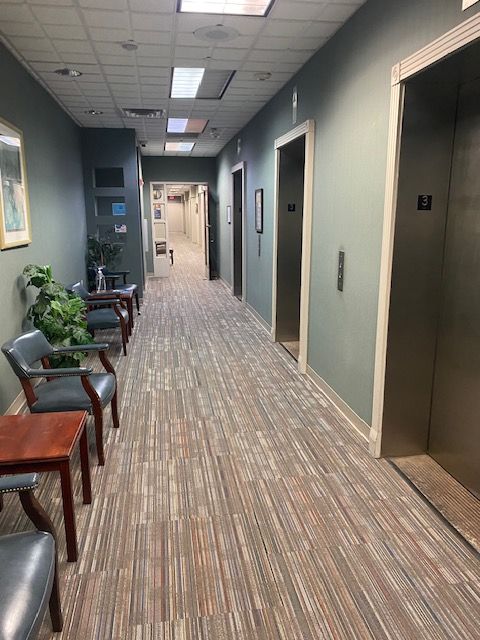 A long hallway with chairs and tables in a building
