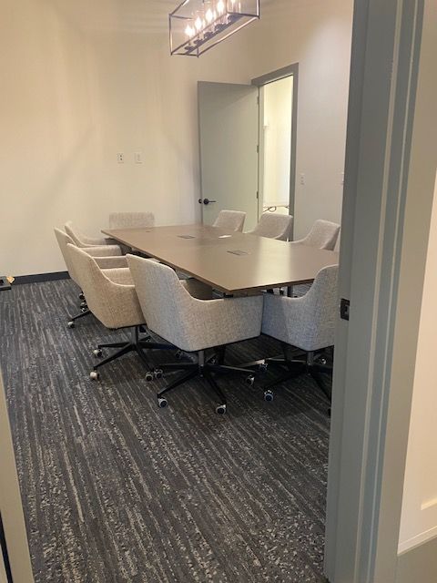 A conference room with a long table and chairs.
