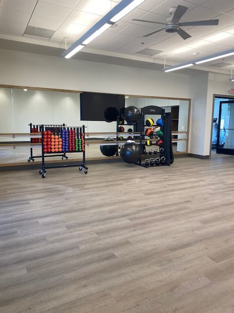 A gym with a large mirror and a ceiling fan