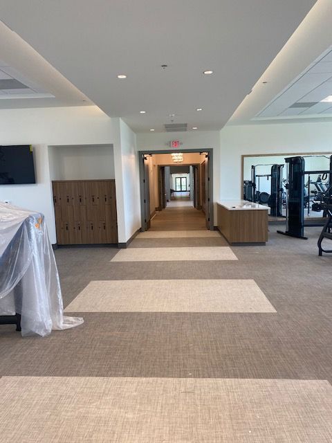 A long hallway leading to a gym in a building