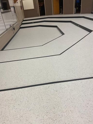 A white tile floor with a black border in a room.