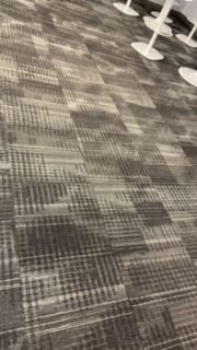 A close up of a carpeted floor in a room with chairs.