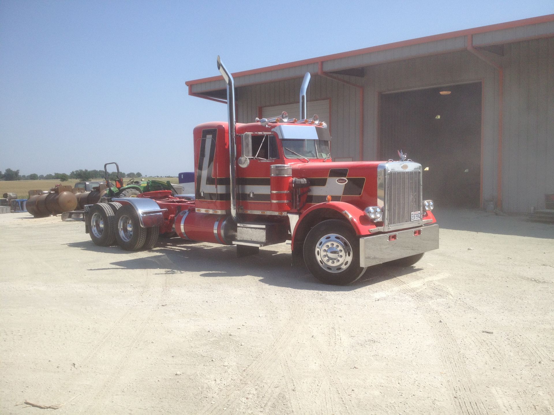 A red semi truck is parked in front of a building