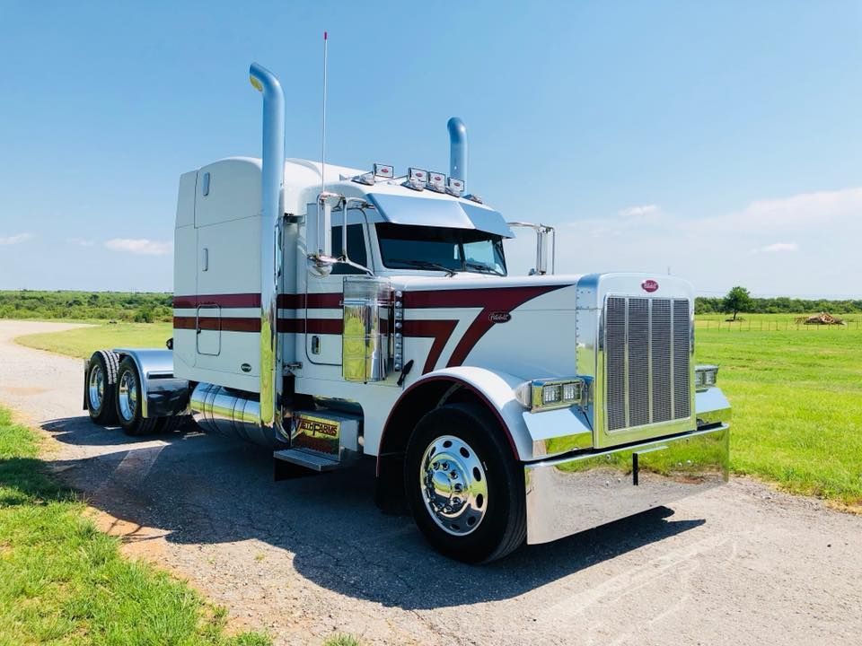 A white semi truck is parked on the side of a road.