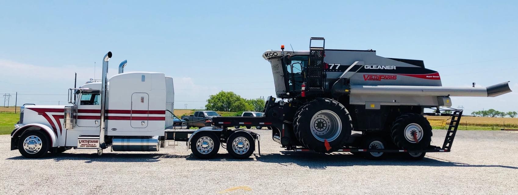 A semi truck is pulling a tractor on a trailer.