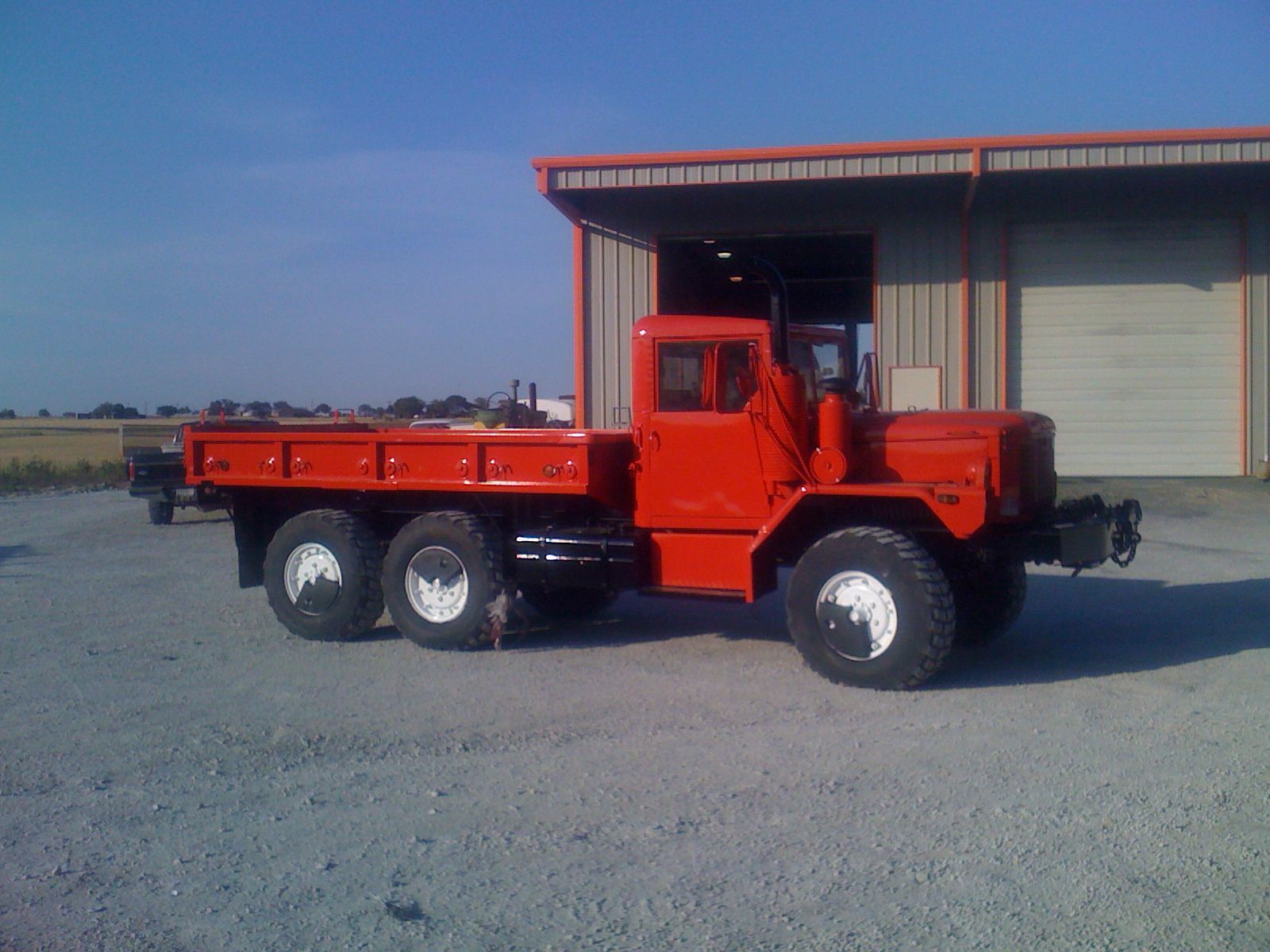 A red truck is parked in front of a building