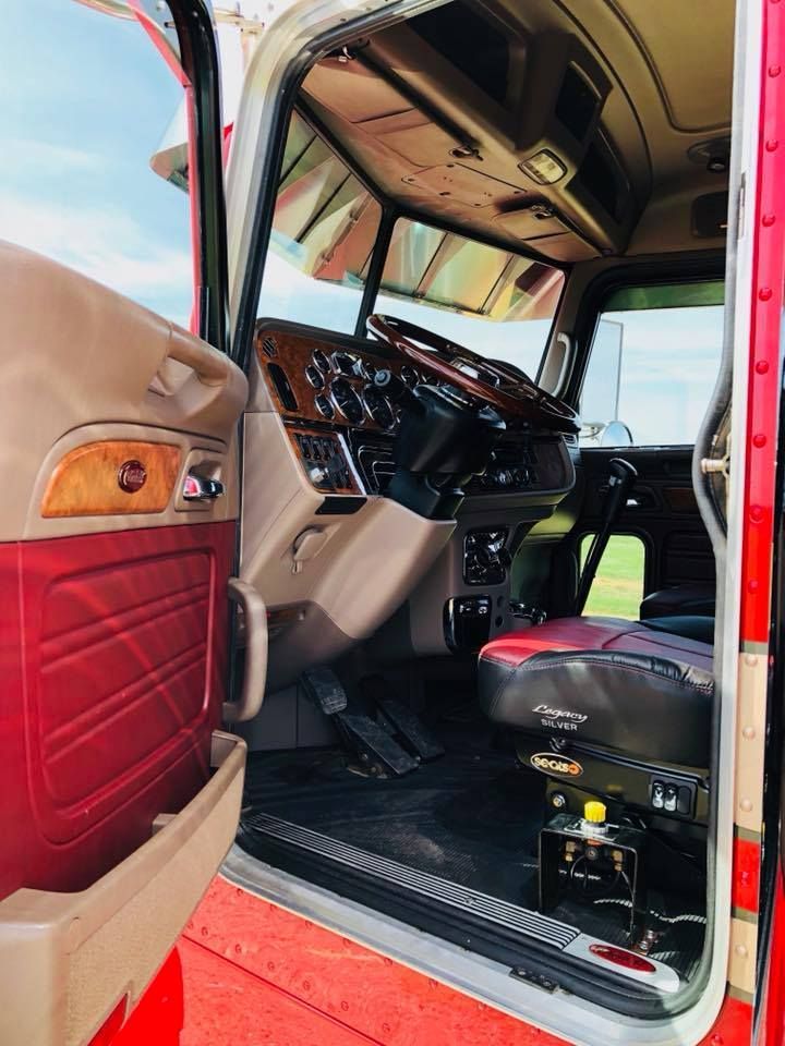 The inside of a red and white semi truck with the door open