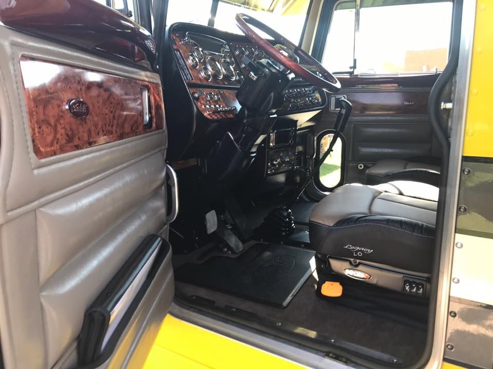 The inside of a truck with the door open and the steering wheel visible.