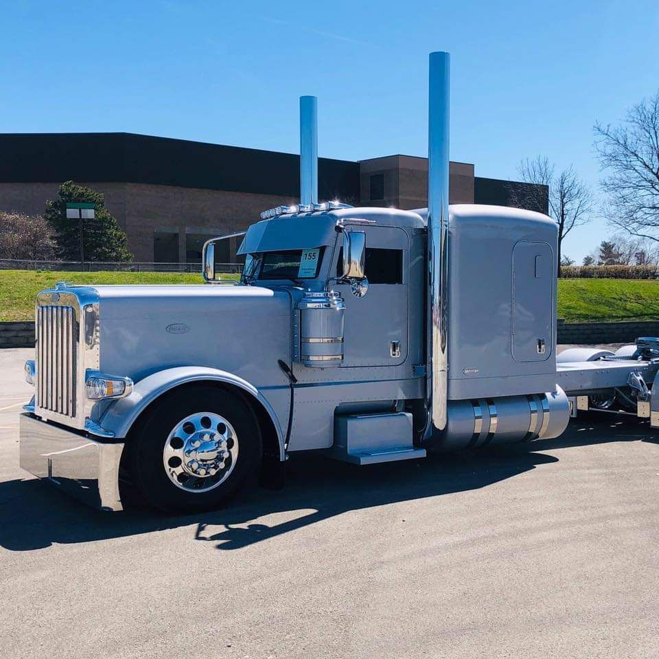 A white semi truck is parked in front of a building