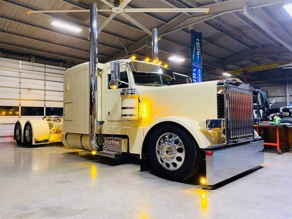 A large semi truck is parked in a garage.