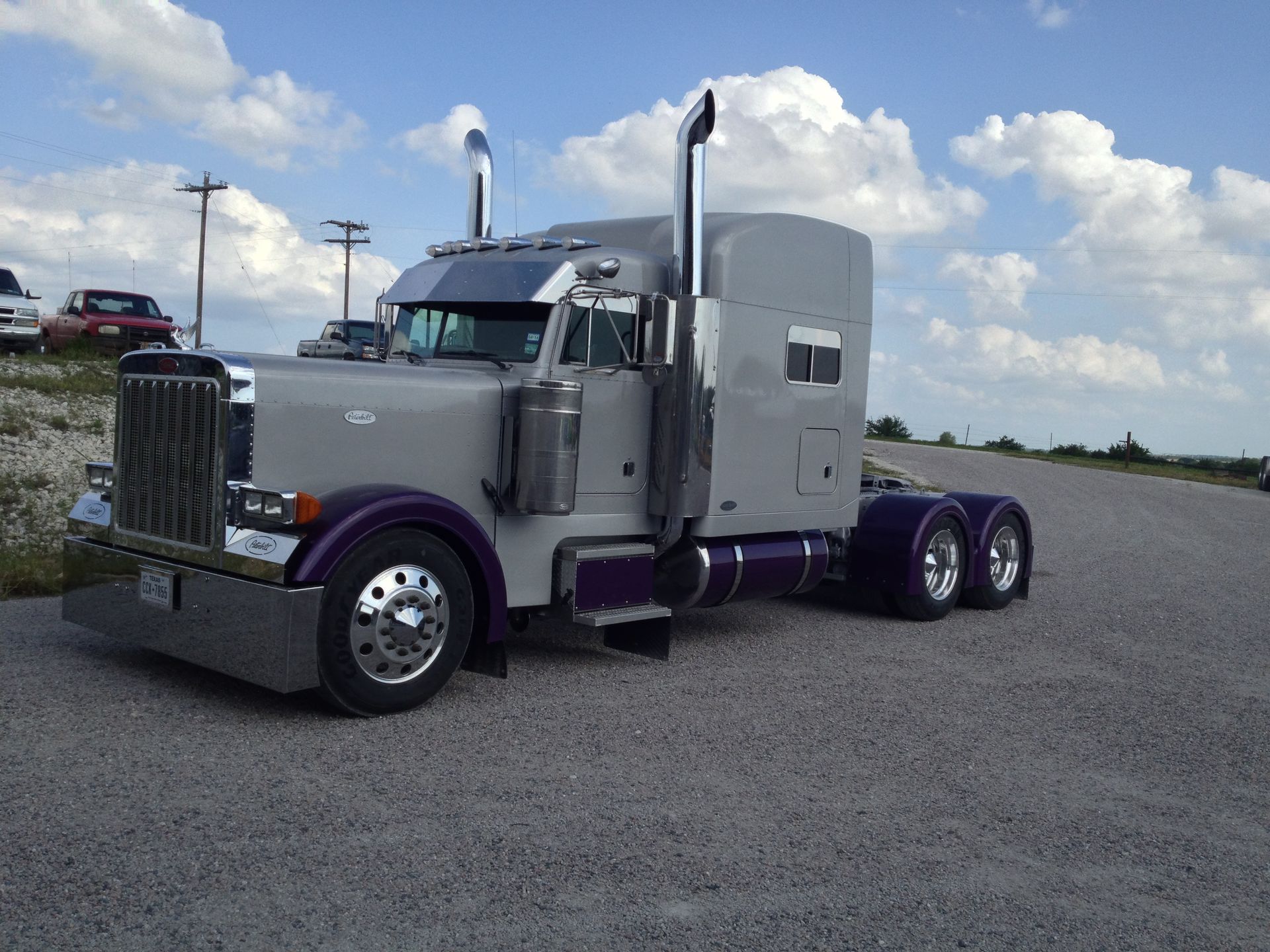 A purple semi truck is parked on the side of the road