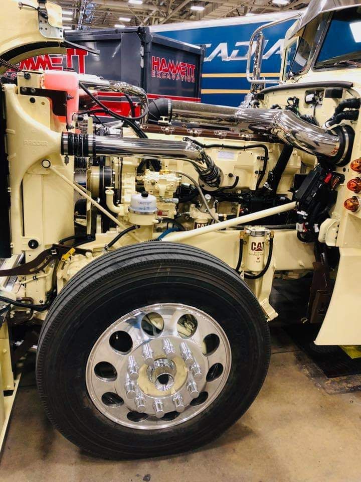 A truck is being worked on with the hood open