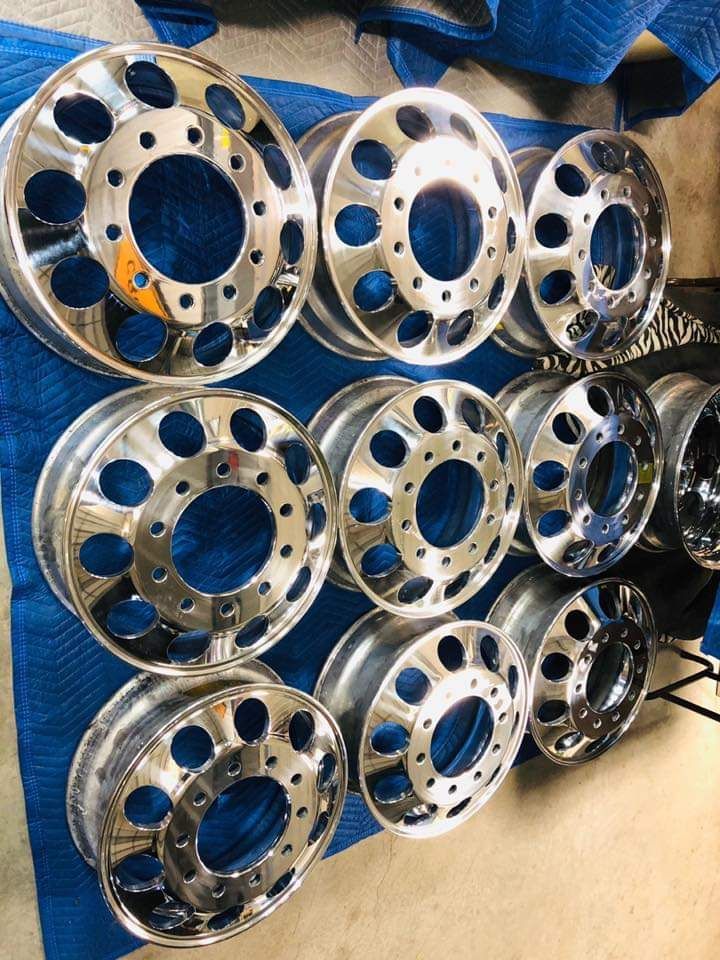 A bunch of chrome wheels are stacked on top of each other