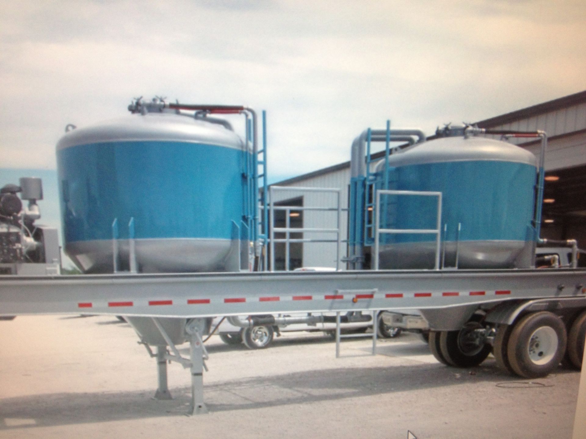 A trailer with two large blue tanks on it
