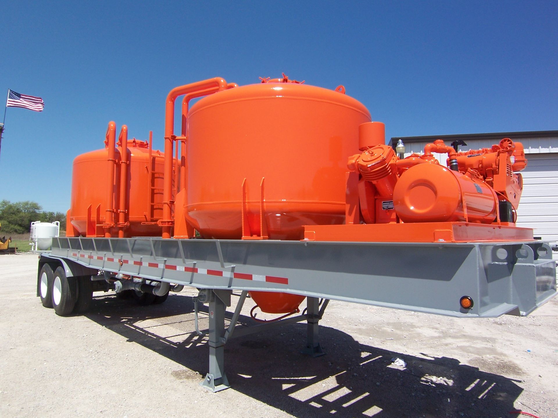 A trailer with a lot of orange tanks on it