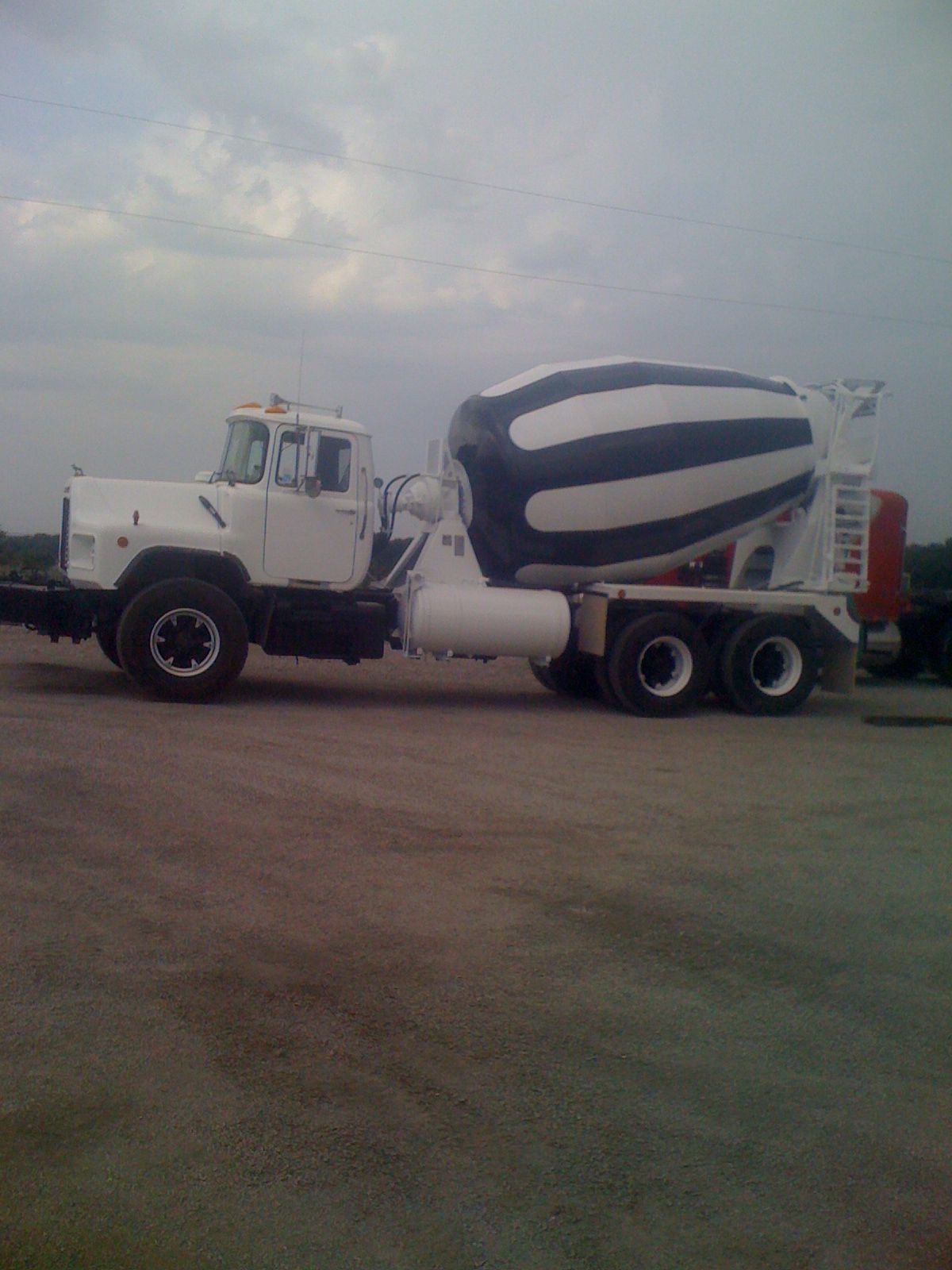 A concrete mixer truck is parked in a parking lot