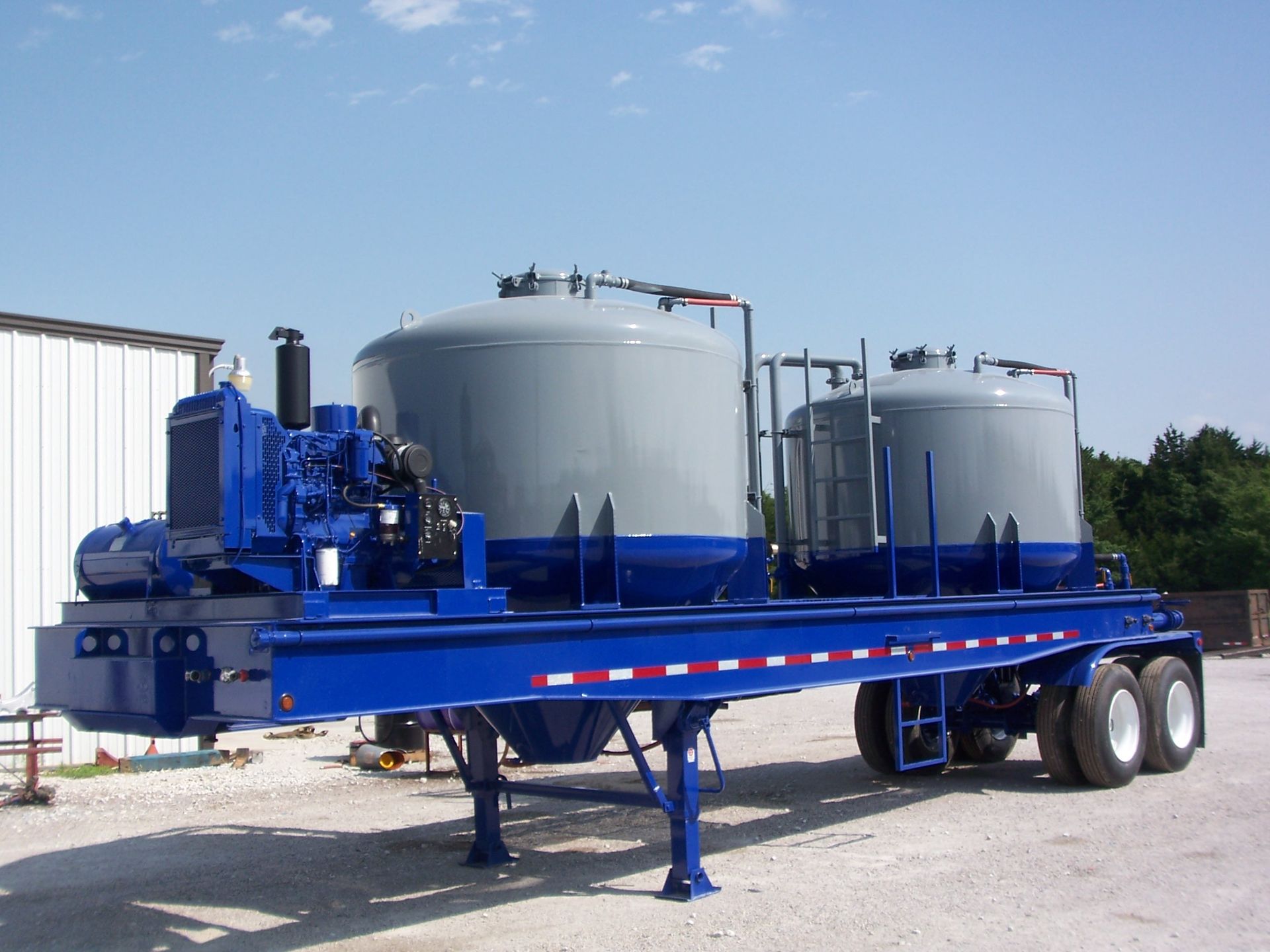 A blue trailer with gray tanks on it